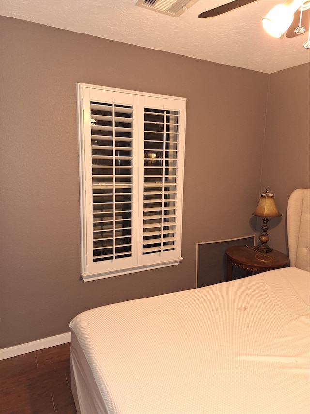 bedroom featuring ceiling fan and dark wood-type flooring