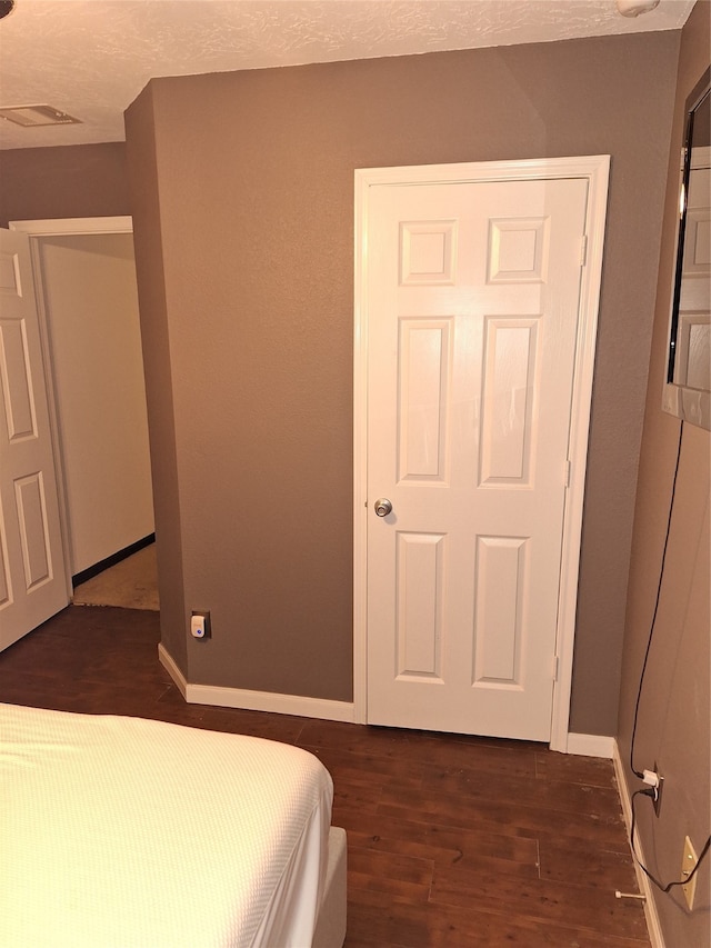 bedroom with dark wood-type flooring