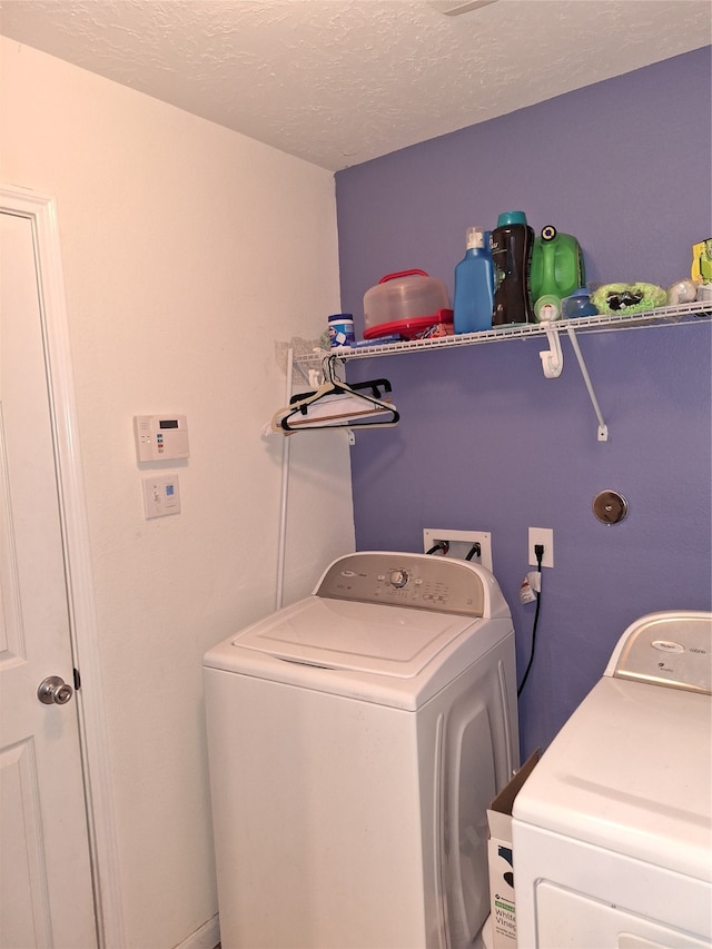 laundry room featuring washer and dryer and a textured ceiling