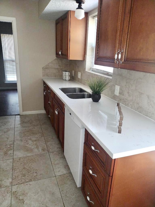 kitchen featuring tasteful backsplash, light wood-type flooring, sink, and dishwasher