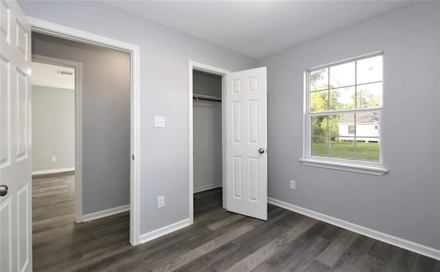 unfurnished bedroom with a closet and dark hardwood / wood-style floors