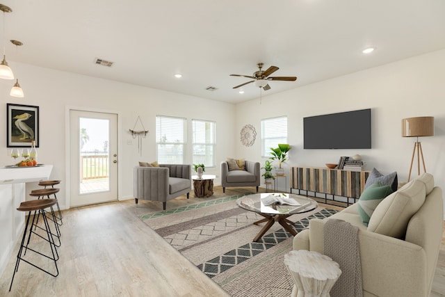 living room with ceiling fan and light hardwood / wood-style flooring