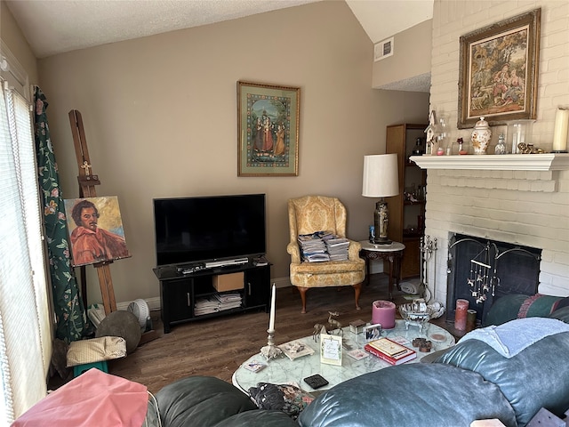 living room featuring lofted ceiling, dark hardwood / wood-style floors, and a brick fireplace