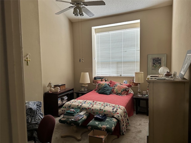 bedroom with multiple windows, light colored carpet, a textured ceiling, and ceiling fan