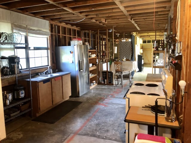 kitchen with sink, hanging light fixtures, stainless steel refrigerator with ice dispenser, and white range with electric stovetop