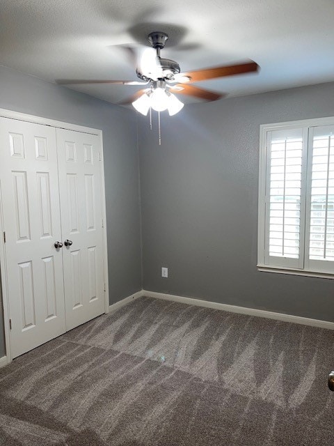 unfurnished bedroom with ceiling fan, a closet, and carpet floors