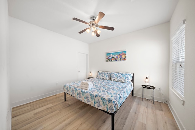 bedroom with multiple windows, ceiling fan, and light hardwood / wood-style flooring