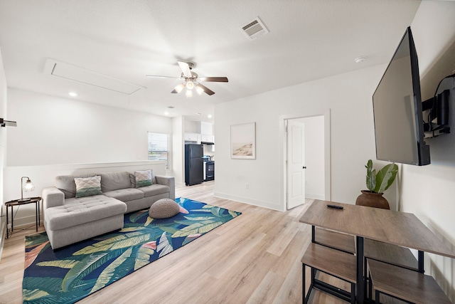 living room with light hardwood / wood-style floors and ceiling fan