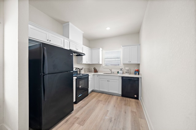 kitchen featuring sink, light hardwood / wood-style floors, white cabinetry, and black appliances