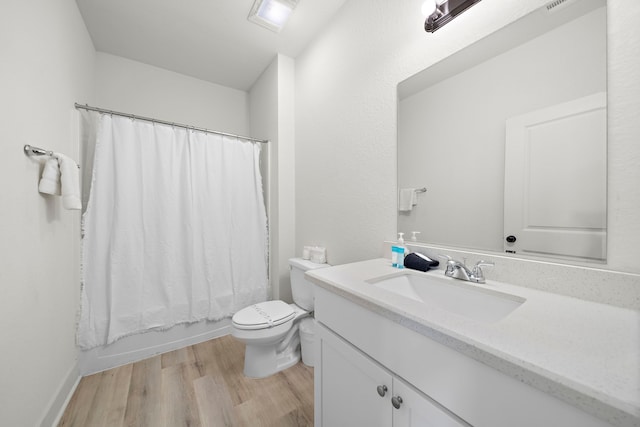 bathroom with hardwood / wood-style flooring, toilet, and oversized vanity