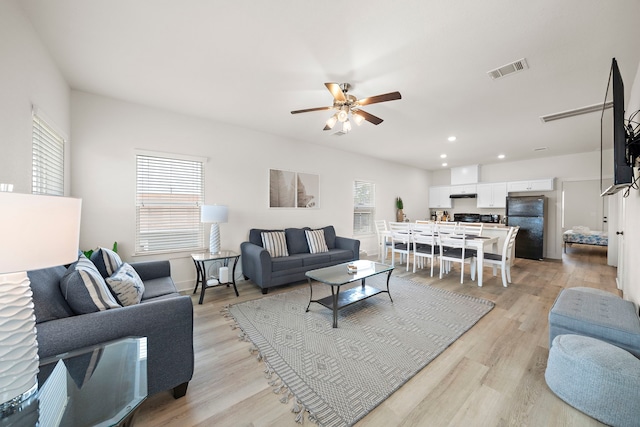 living room featuring ceiling fan and light hardwood / wood-style flooring