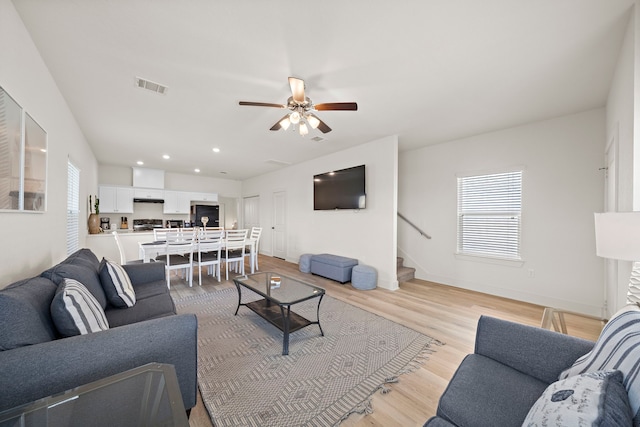 living room with ceiling fan and light wood-type flooring