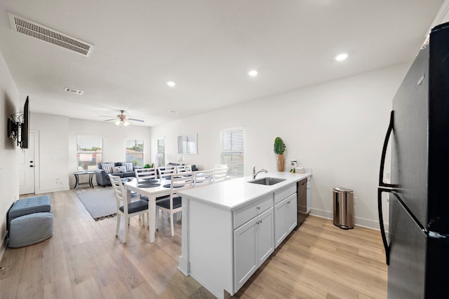 kitchen with ceiling fan, a healthy amount of sunlight, sink, light wood-type flooring, and refrigerator