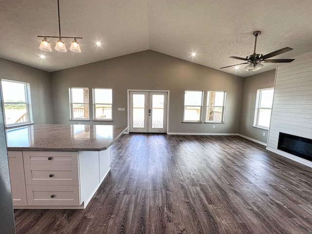 kitchen featuring white cabinets, a textured ceiling, dark wood-type flooring, and vaulted ceiling