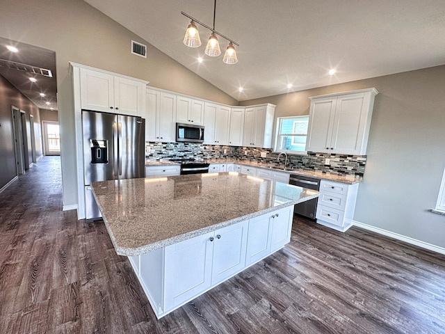 kitchen featuring dark hardwood / wood-style floors, stainless steel appliances, white cabinets, and a center island