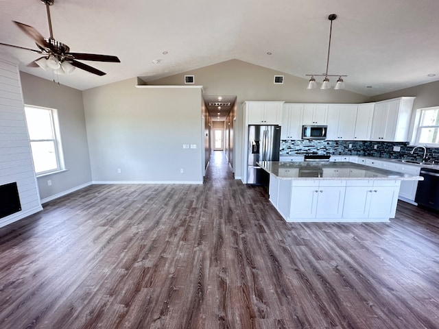 kitchen with dark hardwood / wood-style floors, ceiling fan, white cabinets, stainless steel appliances, and lofted ceiling