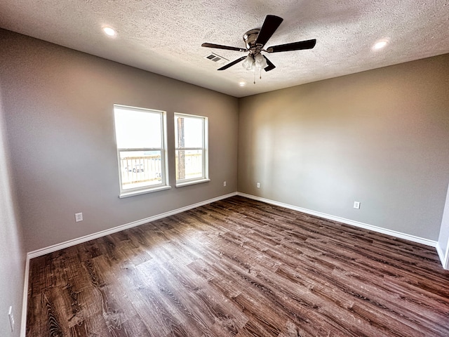 spare room with a textured ceiling, ceiling fan, and dark hardwood / wood-style floors