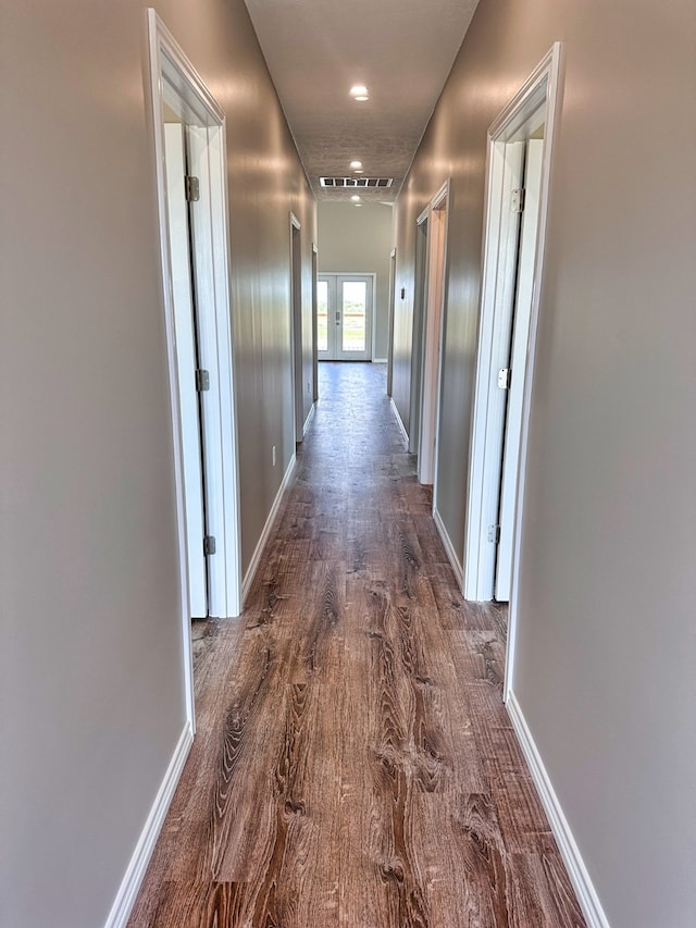 hall with french doors and dark hardwood / wood-style flooring