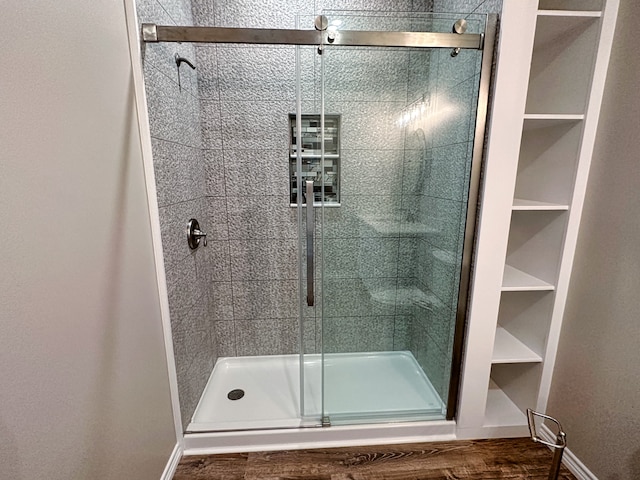 bathroom featuring a shower with shower door and hardwood / wood-style floors