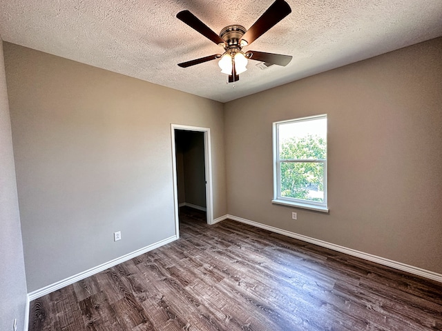 spare room featuring a textured ceiling, dark hardwood / wood-style floors, and ceiling fan