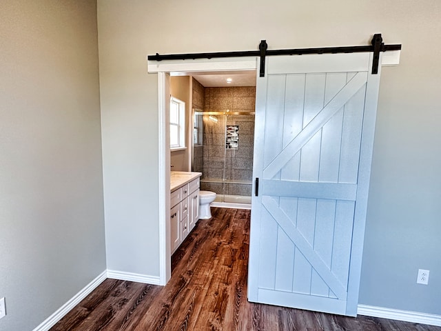 bathroom with vanity, a shower with door, hardwood / wood-style floors, and toilet