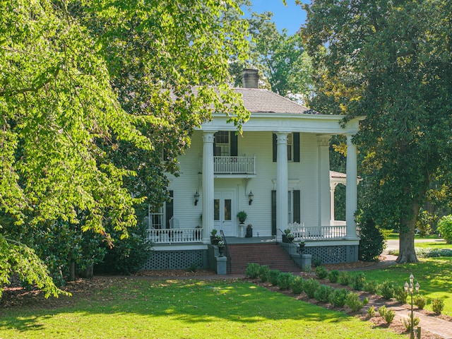 neoclassical / greek revival house featuring a porch, a balcony, and a front lawn