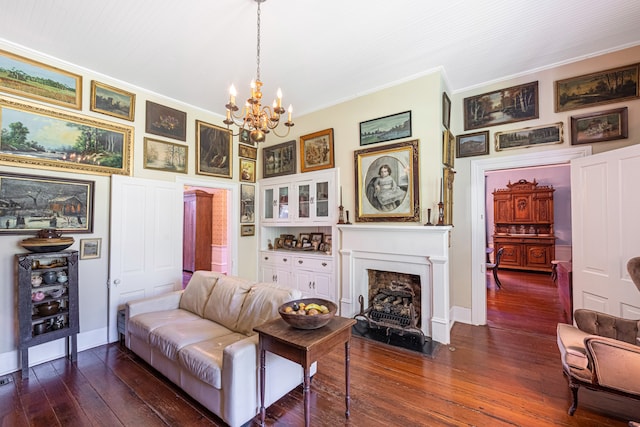 living room with dark hardwood / wood-style flooring, crown molding, and an inviting chandelier