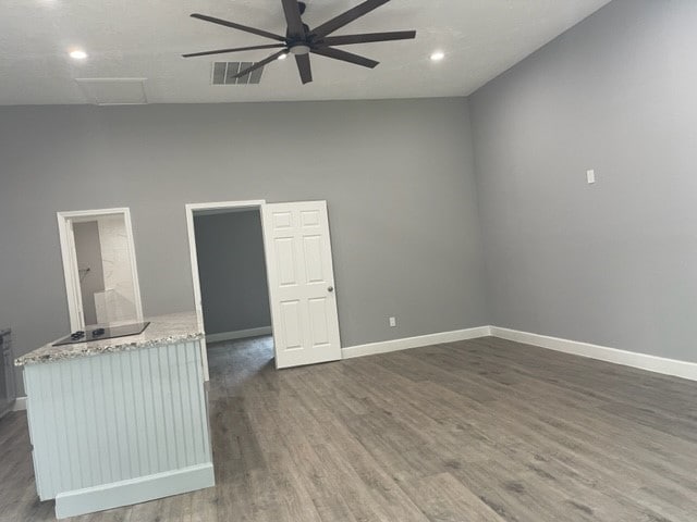 unfurnished room featuring ceiling fan, a textured ceiling, dark hardwood / wood-style floors, and high vaulted ceiling