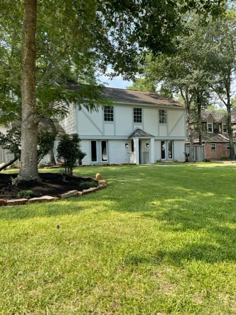 rear view of house featuring a lawn