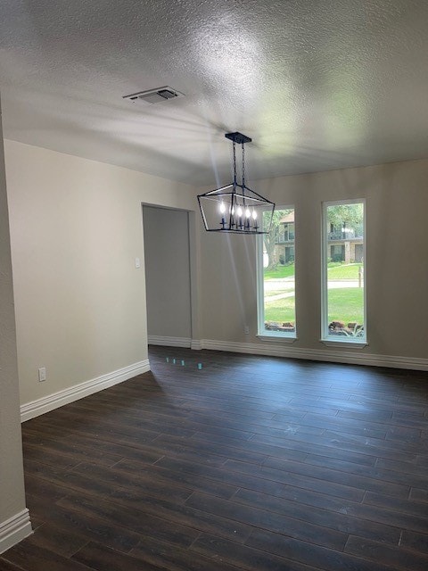 unfurnished room featuring dark wood-type flooring and a textured ceiling