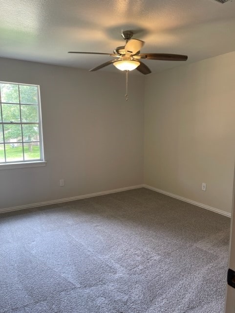 carpeted spare room featuring ceiling fan and a textured ceiling