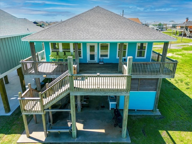 back of property featuring a wooden deck and a lawn