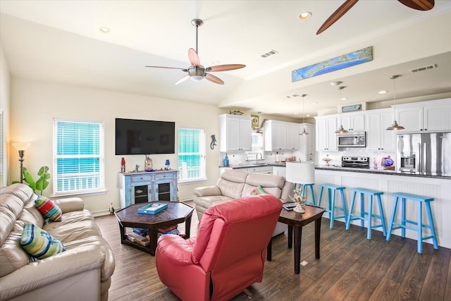 living room featuring ceiling fan and dark hardwood / wood-style floors