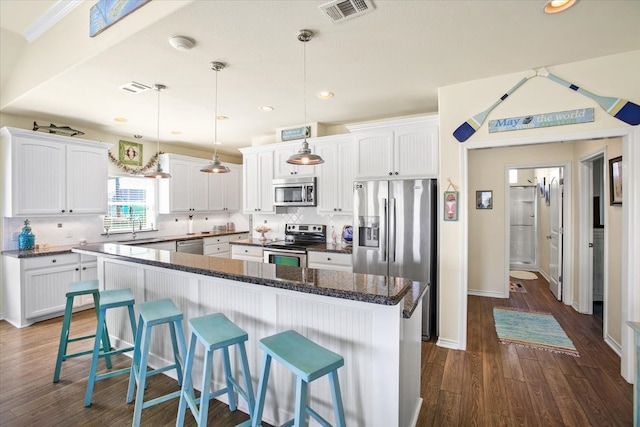 kitchen featuring pendant lighting, stainless steel appliances, and white cabinetry