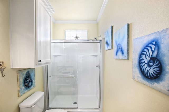 bathroom with a shower with shower door, ornamental molding, and toilet