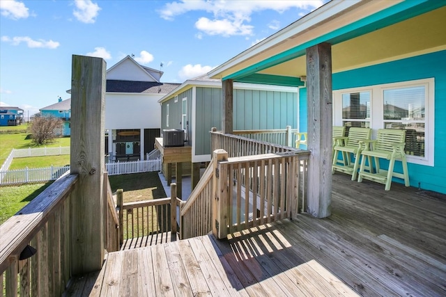 wooden deck featuring a lawn and central AC unit