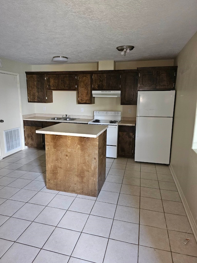 kitchen featuring dark brown cabinets, a textured ceiling, white appliances, sink, and light tile flooring