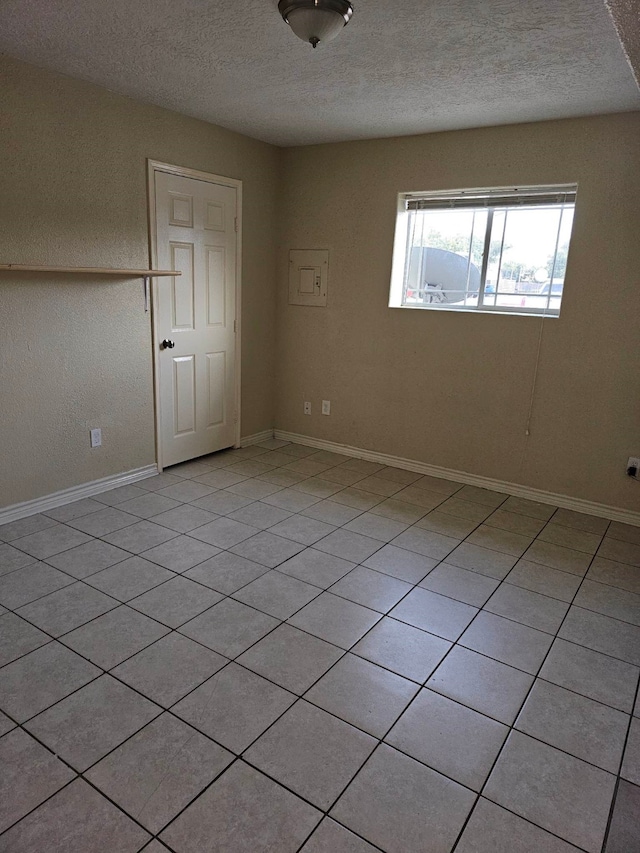 tiled spare room with a textured ceiling