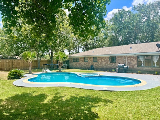 view of pool with an in ground hot tub, a lawn, and a patio