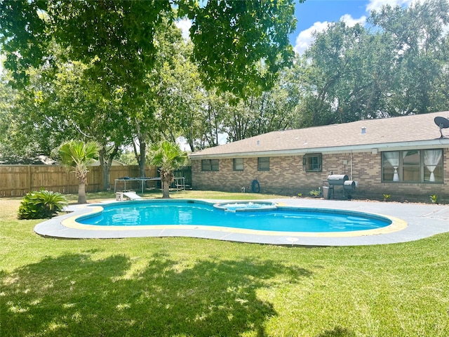 view of swimming pool featuring a water slide and a lawn