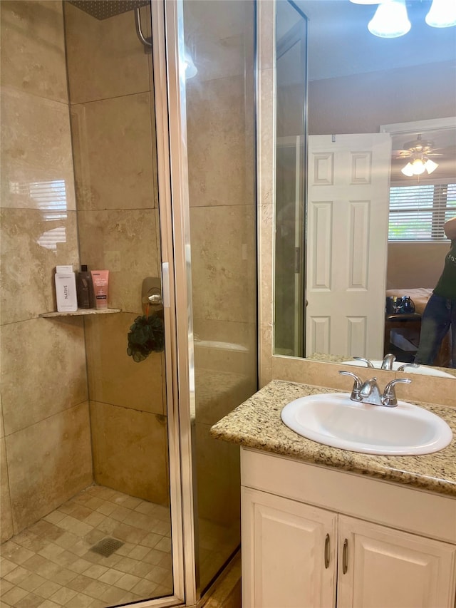 bathroom featuring ornamental molding, vanity, ceiling fan, and walk in shower