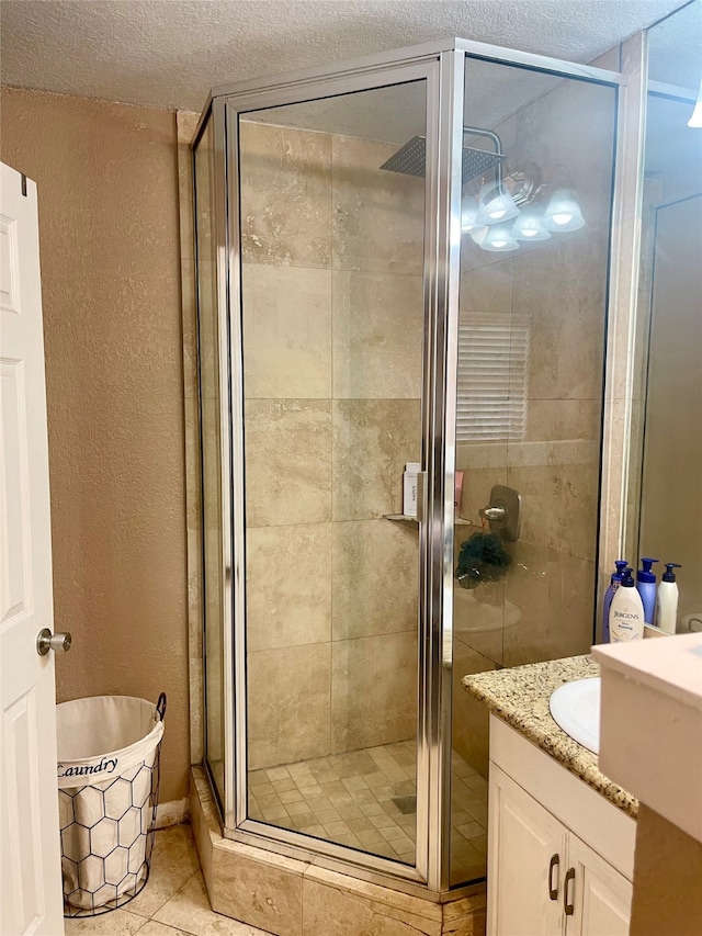 bathroom featuring a shower with door, tile floors, a textured ceiling, and vanity