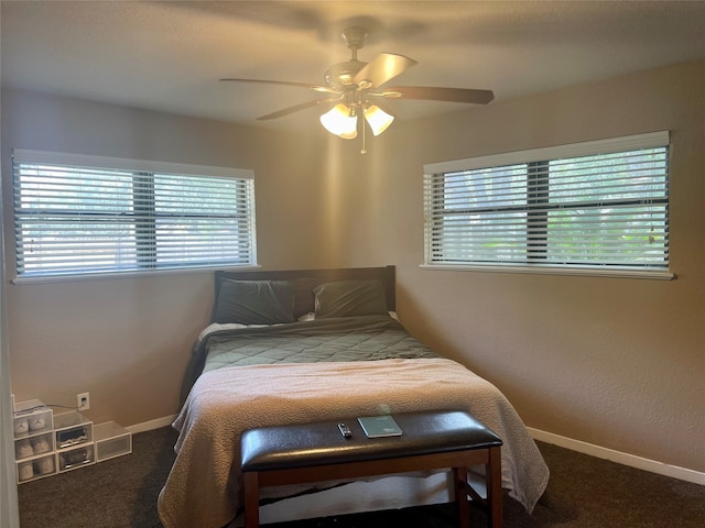 bedroom featuring dark carpet, multiple windows, and ceiling fan