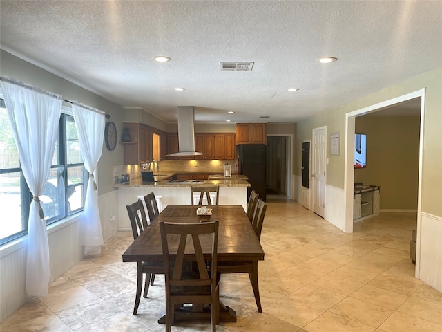 dining space featuring light tile floors, a textured ceiling, and sink