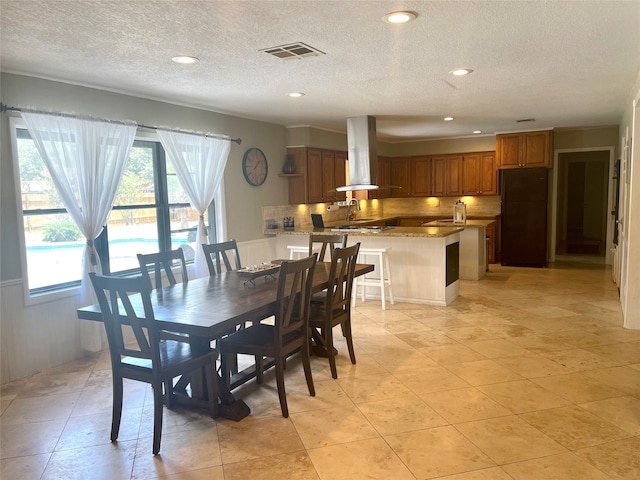 dining space with light tile flooring, sink, and a textured ceiling