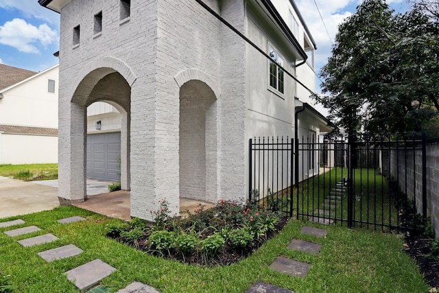 view of side of property featuring a lawn and a garage