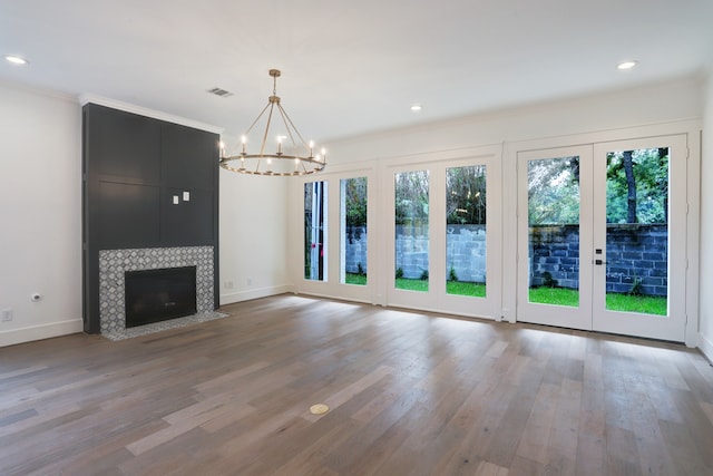 unfurnished living room with light hardwood / wood-style floors, a healthy amount of sunlight, and a chandelier