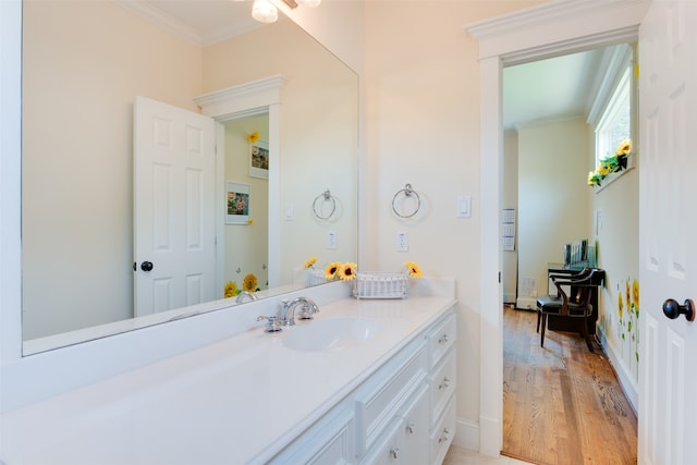 bathroom featuring vanity, ornamental molding, and wood-type flooring