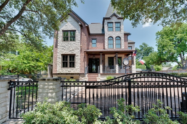 420 Heights Blvd, Houston, TX 77007 - view of front of house with a fenced front yard, a porch, stone siding, brick siding, and a gate