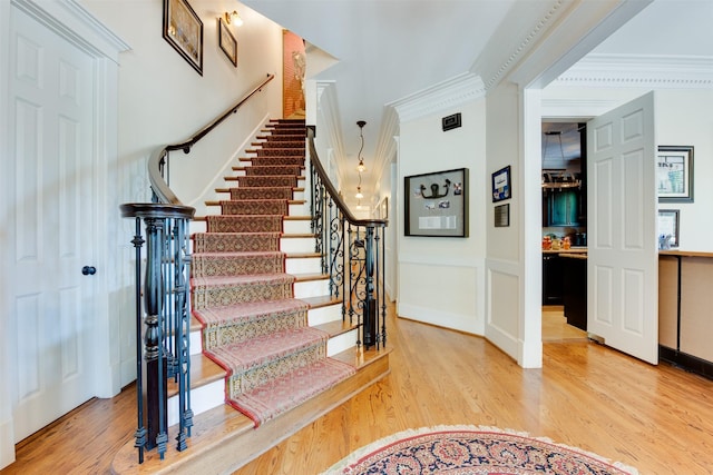 420 Heights Blvd, Houston, TX 77007 - stairway with crown molding, wood finished floors, wainscoting, and a decorative wall